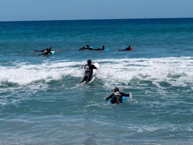 Nico und Alex vom Earlybirdteam paddeln beim TYPO3 Surfcamp aufs Wasser zu einer Gruppe von Surfern
