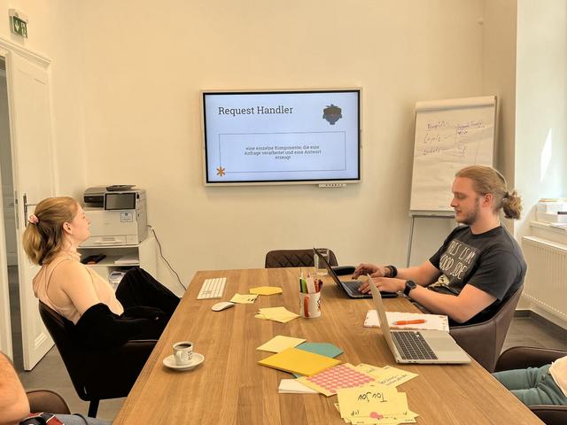 Earlybird Mitarbeiter vor dem Bildschirm bei einer Präsentation beim Earlybird Campus