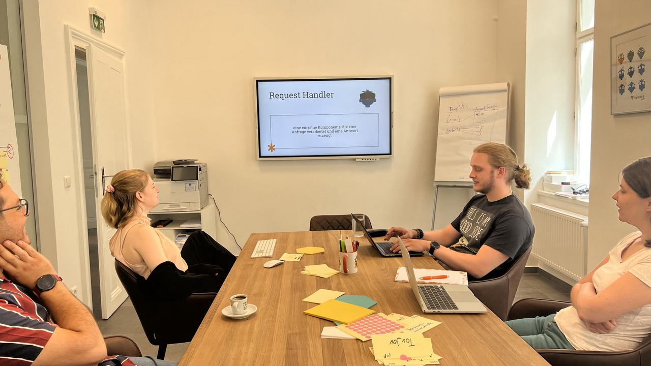 Earlybird Mitarbeiter vor dem Bildschirm bei einer Präsentation beim Earlybird Campus