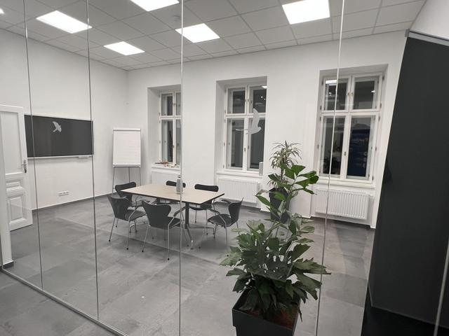 Blick in den Earlybird Meetingraum von außen auf ein analoges und ein digitales Flipchart.